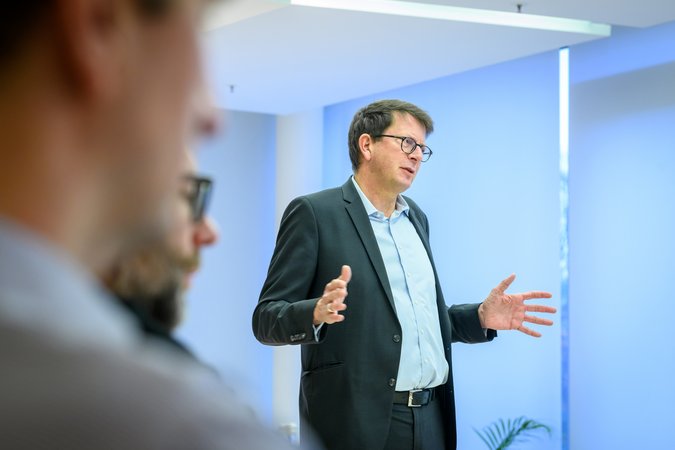 Öffnet eine Lightbox: Ein Mann spricht zu den Teilnehmern 