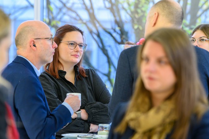 Öffnet eine Lightbox: Teilnehmer stehen im Gespräch beisammen 
